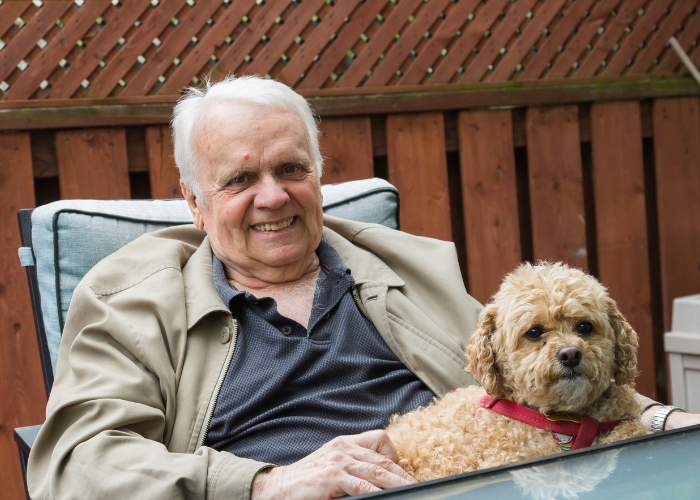 Een senior ontspant met zijn hond.